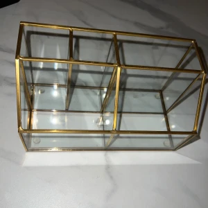 Glasförvaring med mässingsram - Elegant glasförvaring med mässingsfärgade ramar, perfekt för pennor, sminkborstar eller småsaker. I mycket fint skick utan synliga repor eller skador. Stilren design som passar både kontor och hem.