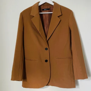Brun kavaj från Gina Tricot - Kavaj i nyskick från Gina Tricot, endast testad hemma. Skönt oversize, med fickor på framsidan och tre knappar i vardera ärmslut. Om man är intresserad så finns även ett par högmidjade palazzobyxor som tillhör kostymen! 👖 