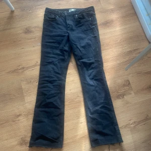 Svarta bootcut jeans från Zara - Svarta jeans från Zara med bootcut passform och råa kanter nertill. Klassisk femficksmodell i mjukt denimtyg, perfekt för en avslappnad och trendig look. Snygga att matcha med sneakers eller boots.