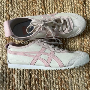 Onitsuka Tiger skor.  - Snygga skor från Onitsuka Tiger med rosa detaljer. Storlek 38. Använda några gånger därav smuts på sulan men det är bara att tvätta bort. Skriv för mer bilder eller övriga frågor. 