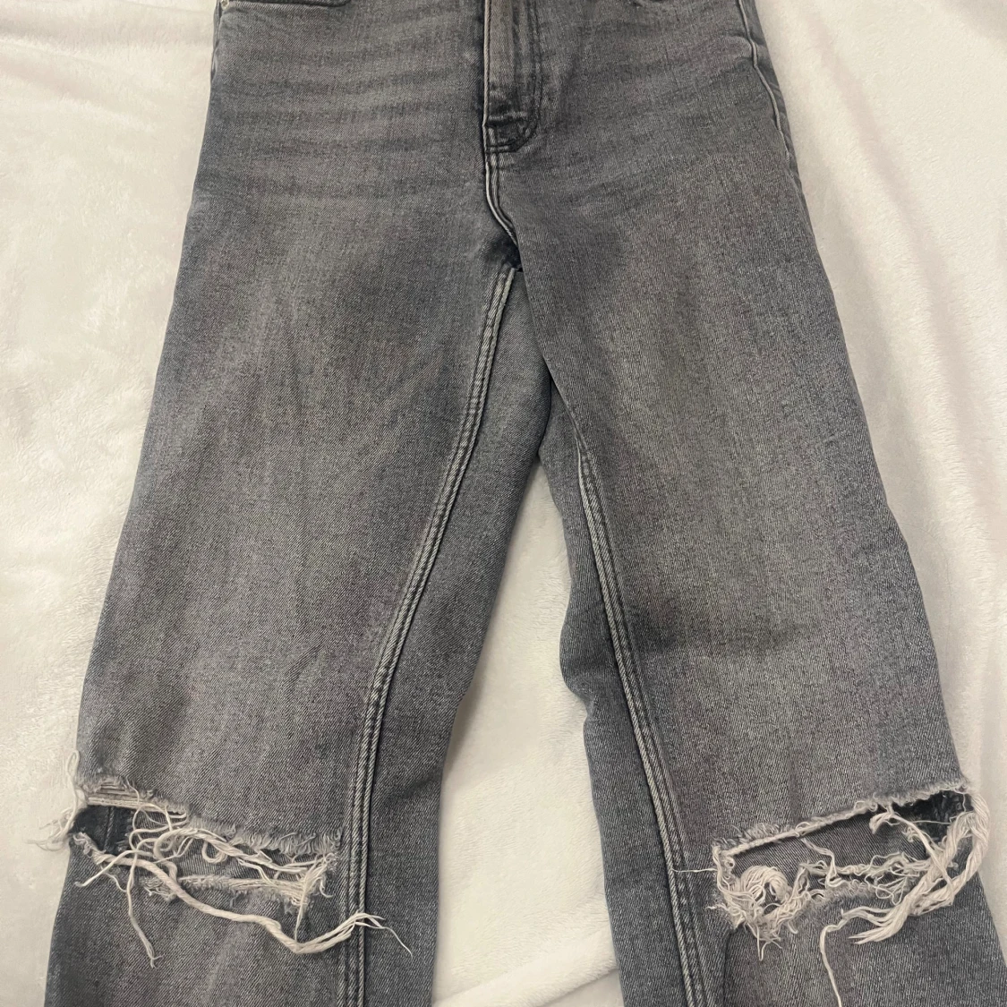 Grå slitna jeans med hål vid knäna - 1