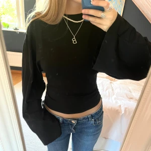 Svart topp med vida ärmar - Fin svart topp med vida ärmar och tight i midjan