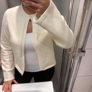 Stickad kofta  - En stickad kofta från Gina tricot, sparsamt använd i Storlek M. Creme vit 