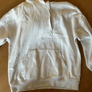 Vit hoodie med magficka och huva - Säljer en stilren vit hoodie med klassisk magficka och huva med snörning. 