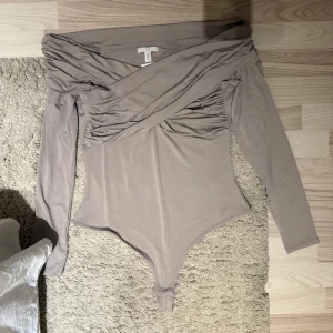 Beige offshoulder body  - Beige offshoulder body från H&M med detaljer i storlek m, helt oanvänd med prislapp kvar