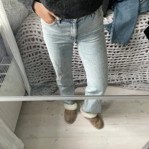 Ljusblå jeans med slits från Monki - Säljer ett par ljusblå jeans från Monki med hög midja och raka ben. Jeansen har en rå kant och en slits på utsidan.