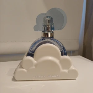 Ariana Grande Cloud EdP 30 ml - Snygg parfym med unik moln-design från Ariana Grande. Perfekt för dig som vill ha en trendig och ikonisk flaska på hyllan. En favorit bland unga fans och samlare. Lite mer än hälften kvar.