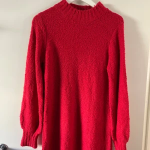 Röd stickad klänning från Kappahl - Mysig röd stickad klänning från Kappahl i storlek XS. Klänningen har lång ärm, ribbad krage och muddar vid ärmslut och nederkant. Perfekt för dig som vill ha en varm och snygg look under kyliga dagar.