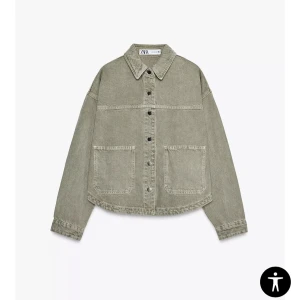 jeans jacka i grön denim från Zara - Snygg jeans jacka från Zara i en dämpad grön nyans. Jackan har klassisk krage, stora bröstfickor och knäppning med metallknappar framtill. Tillverkad i jeansmaterial med raka, långa ärmar och avslappnad passform. Perfekt lager-på-lager-plagg för en cool look.