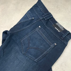 Mörkblå jeans Shine Personal Expression - Snygga mörkblå jeans från Shine Personal Expression med klassisk femficksdesign och kontrastsömmar. Jeansen har rak passform och normal midja, tillverkade i slitstarkt denimtyg. Perfekta för dig som gillar stilrena och tidlösa jeans.
