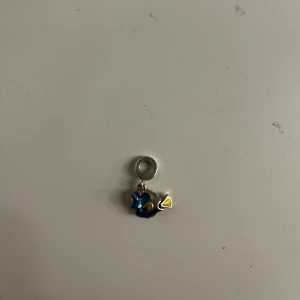 Pandora Dory berlock i silver och blått - Supergullig Pandora-berlock föreställande Dory från Hitta Nemo. Gjord i silver med detaljer i blått och gult emalj. Perfekt att hänga på armband. Berlocken finns inte längre. 