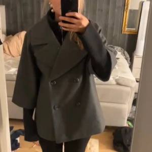 Grå kappa med krage - Säljer en super fin grå kappa med krage och dubbelknäppning framtill. Jackan sitter ihop med en svart inner jacka med lite längre armar och krage💕 knappt använd. Jag är 167 och använder vanligtvis S.