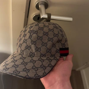 GG-keps beige - GG-keps som är beige med röd och svart på sidan, helt ny nästan helt oanvänd. Kom dm för frågor och mer bilder !