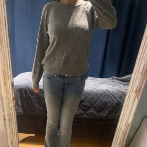 Grå ribbstickad tröja från Lindex - Mysig grå ribbstickad tröja från Lindex med rund hals och långa ärmar. Tröjan har en klassisk passform och är perfekt för kyligare dagar. Enkel att matcha med jeans eller kjol. Knappt använd!