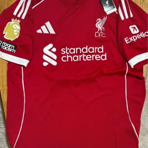Liverpool Salah #11 fotbollströja Adidas - Röd Liverpool FC matchtröja med vita detaljer, Adidas-logga och klubbmärke på bröstet. Tryck med Standard Chartered, Premier League-patch och Expedia på ärmarna. Baksidan har M. Salah och nummer 11 i vitt. Tillverkad i lätt polyester, kortärmad och slim fit.