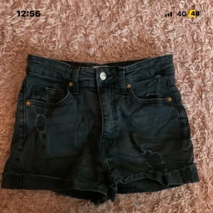 Svarta högmidjade jeansshorts H&M - Snygga svarta jeansshorts från H&M i storlek 36. Modellen är högmidjad med klassiska fem fickor, slitna detaljer och uppvikta benslut för en cool vibe. Perfekta till sommaren och passar till allt. Materialet är bomull med lite stretch.