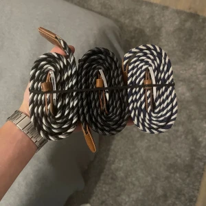  flätade bälten med läderdetaljer - Tre snygga flätade bälten med randigt mönster i svart, vit och marinblå. Bältena har coola läderdetaljer vid spännet och är gjorda i ett slitstarkt syntetmaterial. Perfekt för att ge outfiten en fräsch och ungdomlig touch. Priset kan diskuteras vid snabb affär. Alla tre ingår i priset! Bara skriva vid nån fråga!