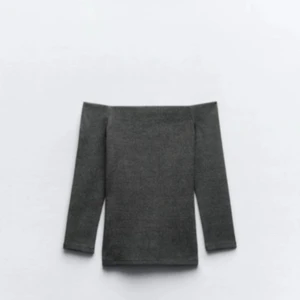 Mörkgrå offshoulder topp - Säljer en stilren mörkgrå offshoulder topp med nästan trekvarts ärmar. Toppen har en tight passform och är tillverkad i mjuk bomullsmix som sitter snyggt på kroppen. Perfekt för dig som gillar minimalistisk och trendig stil.