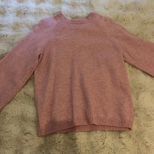 Rosa stickad tröja från ONLY - Mysig rosa stickad tröja från ONLY i storlek 158-164. Tröjan har rund hals, långa ärmar och ribbade muddar vid ärmslut och nederkant. Perfekt för dig som gillar en enkel och chill stil med mjukt material.