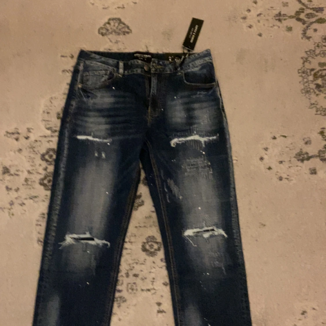 Mörkblå distressed jeans med slitningar