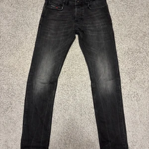 Svarta jeans från Diesel, slim fit - Snygga svarta jeans från Diesel med diskret tvättad look och klassisk femficksdesign. Slim fit-modell med normal midja och raka ben. Jeansen har svart Diesel-logga på bakfickan och är tillverkade i mjukt jeanstyg med lite stretch för extra komfort.