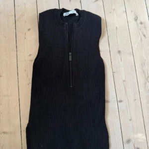Svart ribbad stickad väst med zip - Svart stickad väst från Zara med ribbad struktur och half zip framtill.