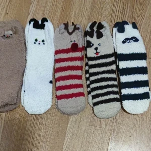 Fem par fluffiga djurstrumpor - Fem par supermjuka och fluffiga strumpor med söta djurmotiv. Färgerna är beige, vit, röd, svart och grå, och flera har randigt mönster. Strumporna har detaljer som öron och ansikten på skaftet, perfekt för att mysa hemma under vintern. Obs Jag har mer om man vill ha.