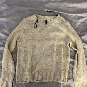 Beige stickad tröja från H&M  - Beige stickad tröja från H&M i storlek XS. Tröjan har en klassisk rund halsringning, ribbade muddar och är långärmad. 