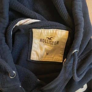 Blå Hollister hoddie - En blå hollisterhoodie i bra skicka. Lite tunnare material. Ärmarna är ganska långa. Det står m men passar som S. Priset kan diskuteras. Skriv om ni undrar något. 👍