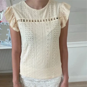 Gul blus med spets och volangärm - Säljer en söt  gul blus med broderade detaljer och spetsband över bröstet