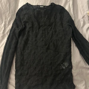 Svart spetsblus från Bikbok - Säljer en svart långärmad blus från Bikbok i storlek S. Blusen är helspets med ett snyggt blommigt mönster och har en rund halsringning. Perfekt för dig som gillar detaljer och vill ha en elegant look med lite edge.