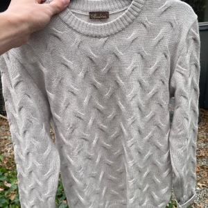 Beige stickad tröja från Stenströms - Snygg beige stickad tröja från Stenströms med unikt strukturerat mönster över hela plagget. Rund halsringning och ribbade muddar vid ärmslut och nederkant. Perfekt för dig som gillar stilrena och bekväma plagg med lite extra detaljer.