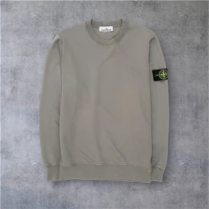 Stone Island sweatshirt - Säljer en grå crewneck sweatshirt från Stone Island med klassisk patch på vänster ärm. Tröjan har rund halsringning, ribbade muddar och är tillverkad i mjuk bomull. Enkel och stilren design som passar perfekt till jeans eller joggers. Ny inga defekter köpt för 2500. Först till kvarn!