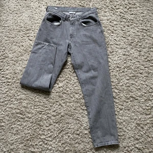 Grå jeans från Vailent, storlek M - Säljer ett par grå jeans från Vailent i storlek M. Byxorna har klassisk femficksdesign, raka ben och normal passform. Materialet är slitstarkt denim och färgen är en snygg, lite tvättad grå ton. 