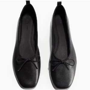 Svarta ballerinaskor i läder - Stilrena svarta ballerinaskor från H&M i mjukt läder med rund tå och söt rosettdetalj framtill! Endast använda en gång🖤