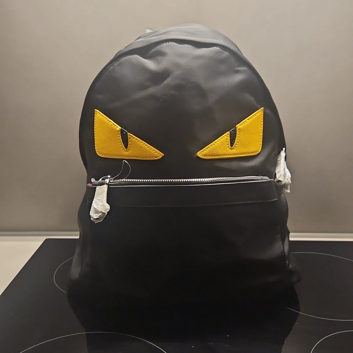 Svart ryggsäck med gula ögon