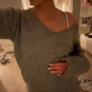 Grå stickad v-ringad tröja - Mysig grå stickad tröja från lager 157 med v-ringning och lång ärm. Tröjan har en loose passform och kan bäras offshoulder för en avslappnad vibe. Perfekt till höst och vinter, superenkel att styla med jeans eller leggings.