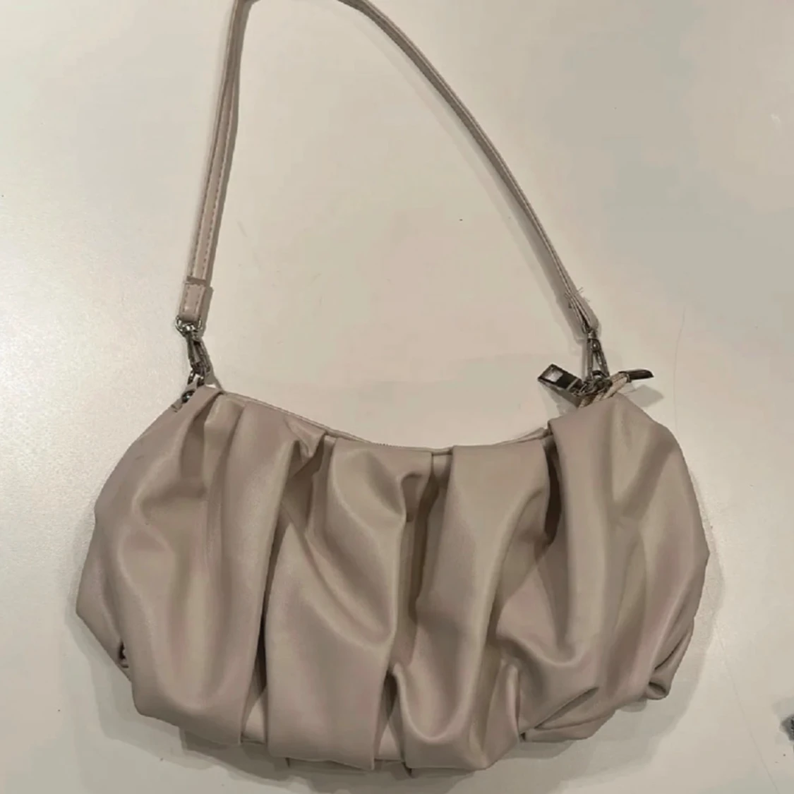 Beige axelväska med veckad design