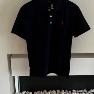 Marinblå Polo Piké  - Säljer denna helt nya, riktigt fina Polo Ralph Lauren piké med storleken S. Skriv gärna vid intresse och för mer info!