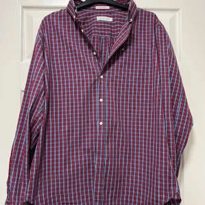 Rutig skjorta från Peak Performance L - Rutig skjorta från Peak Performance i rött och blått med vita detaljer. Fin kvalité och fint skick. Klassisk krage, långärmad och knäppning framtill samt vid ärmslut. Regular fit och tillverkad i mjuk bomull. Perfekt för en chill och snygg look. Snygg till jul!