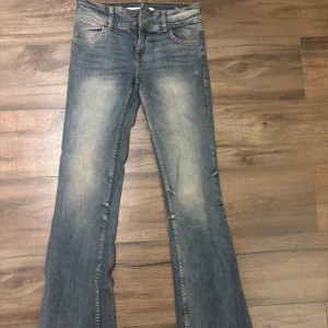 Blå bootcut jeans från Bershka - Snygga blå jeans från Bershka i bootcut-modell med klassisk femficksdesign. Jeansen har en lätt tvättad look och subtila slitningar längs benen. ❣️hör av er vid frågor, köparen står för frakten ❣️