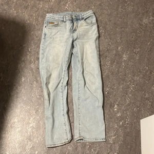 Ljusblå straight jeans från Lee - Säljer ett par ljusblå jeans från Lee med klassisk femficksdesign och raka ben. Jeansen har en snygg tvättad look, Lee-lapp på bakfickan och är tillverkade i mjukt jeanstyg. Perfekt för dig som gillar avslappnad stil.