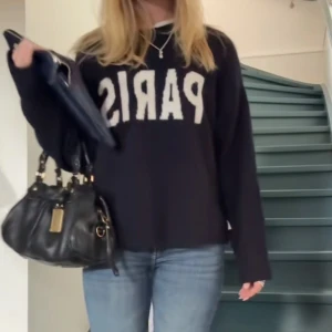 Svart stickad tröja med PARIS-tryck HM - Svart stickad tröja från HM med vit text 'PARIS' framtill. Tröjan har rund halsringning, långa ärmar och en lite loose passform. Perfekt för dig som gillar statement-plagg och vill ha en mysig men trendig look. Köpt för 2 veckor sedan på HM, använt inte mer än 1-2 gånger! Pris går att diskutera.