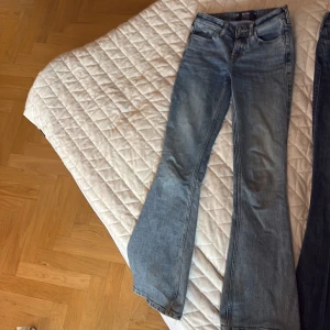 Lågmidjade flare jeans från Hollister - Snygga blå jeans från Hollister med låg midja och utsvängda ben. Modellen är klassisk flare med stretchigt denimtyg som sitter skönt. Perfekta för dig som gillar en retro vibe och vill ha ett par jeans som sticker ut lite extra.