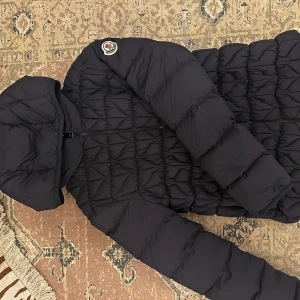 Moncler jacka  - Köpt för ca 2-3 år sedan. Använd ett fåtal gånger. Tror inte modellen säljs längre. Så så fin! Är i den största barnstorleken så det motsvarar XXS/XS eller 32/34. Passar mig som är 164 cm lång. Köpt online på Moncler egna hemsida 