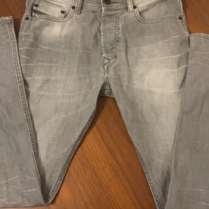 Diesel grå skinny/slim jeans W29 L30 - Snygga grå jeans från Diesel med slim passform och klassisk femficksdesign. Jeansen har en lätt tvättad look och smal siluett som sitter tajt längs benen. Perfekta för dig som gillar stilrena och moderna jeans med cool vibe.