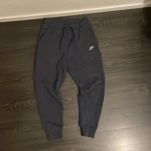 Nike Tech Fleece pants – navy blue 💙 - 👖 Mörkblå Nike Tech byxa – clean & bekväm! Säljer ett par Nike Tech Fleece byxor i mörkblått. Sitter snyggt och är superbekväma – perfekt till både träning och vardag 👟 Använd få gånger, inga fläckar eller skador.