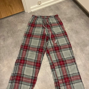 Högmidjade pyjamasbyxor - Säljer ett par rutiga högmidjade pyjamasbyxor. Vida i benen och jättebekväma.