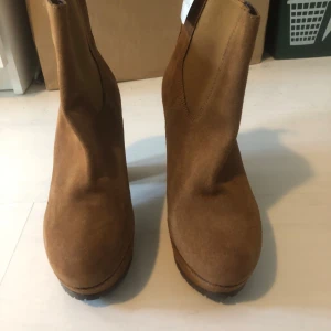 Bruna mocka stövletter från Catwalk - Snygga bruna stövletter i mocka från Catwalk med rund tå, plattformar och robusta sulor med bra grepp. Från vad jag vet säljs de här inte längre. Kommer med lapp, men inte med separat skolåda. Perfekta för den som vill ha en bekväm höstlook.
