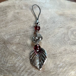 Väsksmycke  - Väsksmycke/phone-charm av glaspärlor, silverlöv och rostfritt stål🪻🍃💍